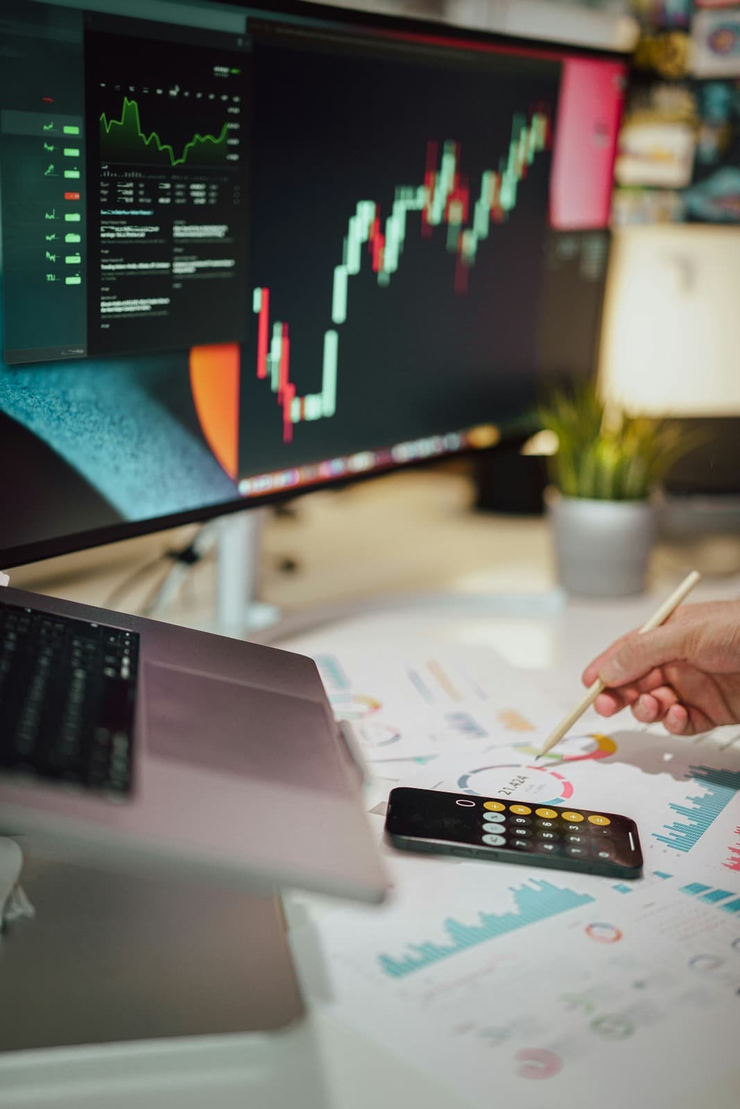 Analyst reviewing market charts and printed diligence materials